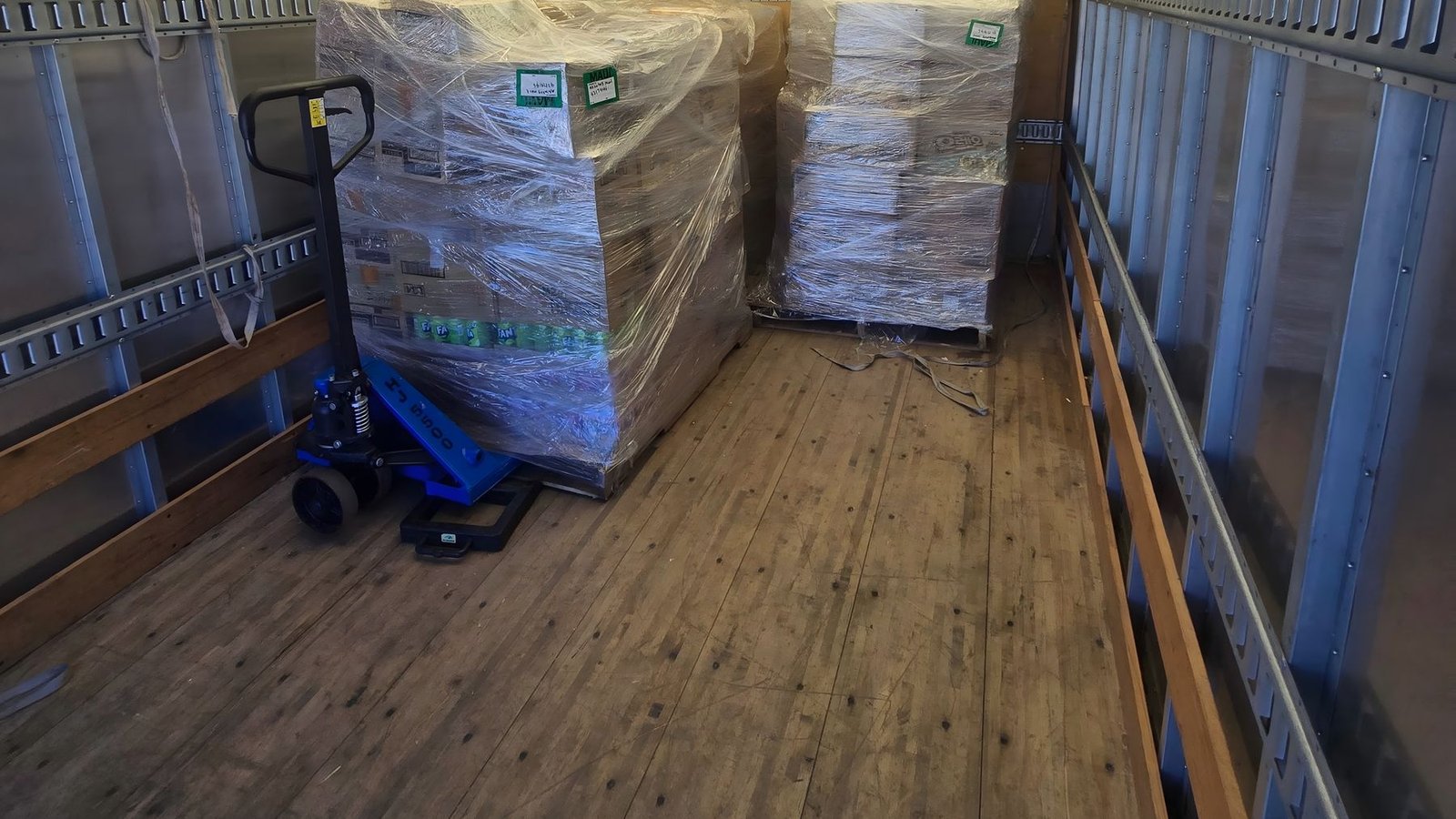 Wrapped pallets of boxed freight loaded in the back of a box truck